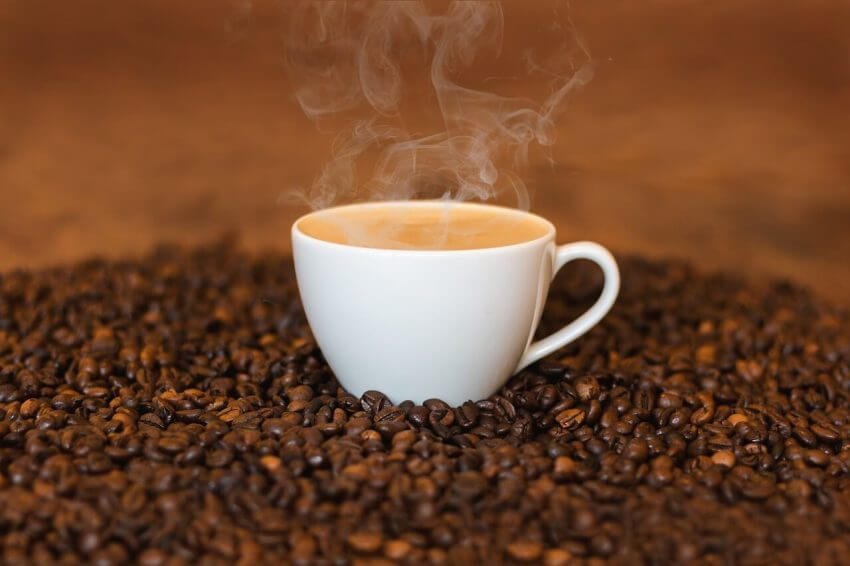 En kopp kaffe på en bädd av kaffebönor